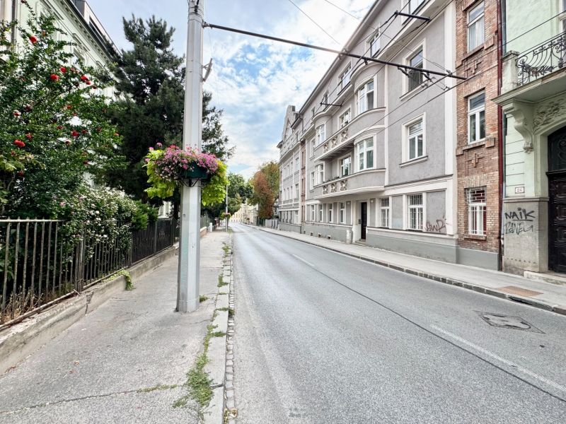 Palisades in the Old Town of Bratislava with historic buildings and floral decorations on the column.