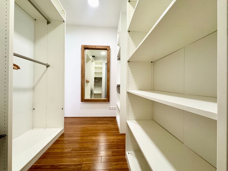 A wardrobe in a 3-room apartment with shelves and a wooden decor floor.