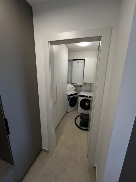 Laundry room with a white washing machine and dryer in a 3-room apartment.