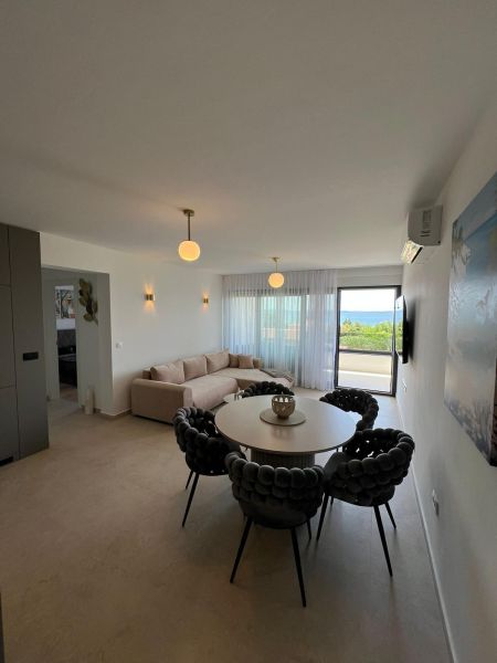 Living room of a 3-room apartment with a round table, sofa, and view.