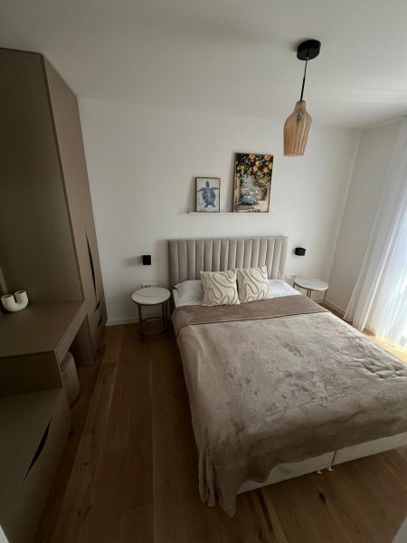 A bedroom in a 3-room apartment with a bed, a cabinet, and a floor with a wooden decor.
