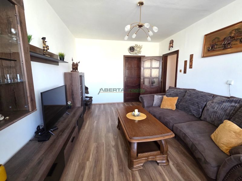 Living room with a comfortable sofa and a wooden decor floor in a 3-room apartment.