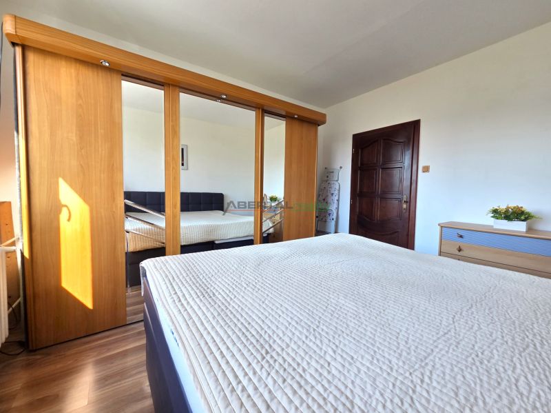 Bedroom in a 3-room apartment with a large wardrobe and a floor with a wooden decor.