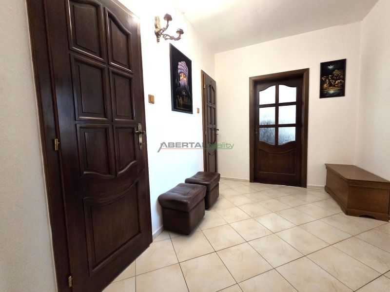 A hallway in a 3-room apartment with brown doors and tiles.