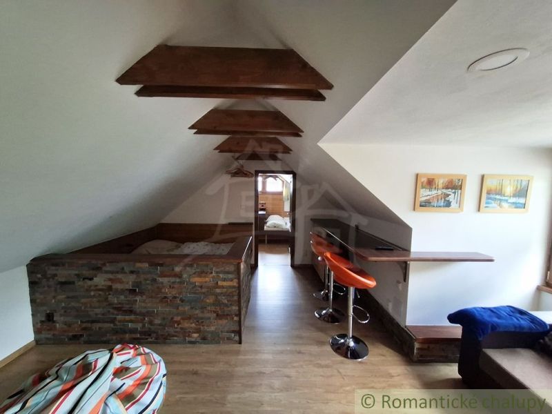 The interior features a wooden decor floor, bar stools, and stone cladding.