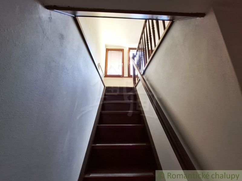 A staircase with a wooden railing leading to the upper part of the commercial premises.