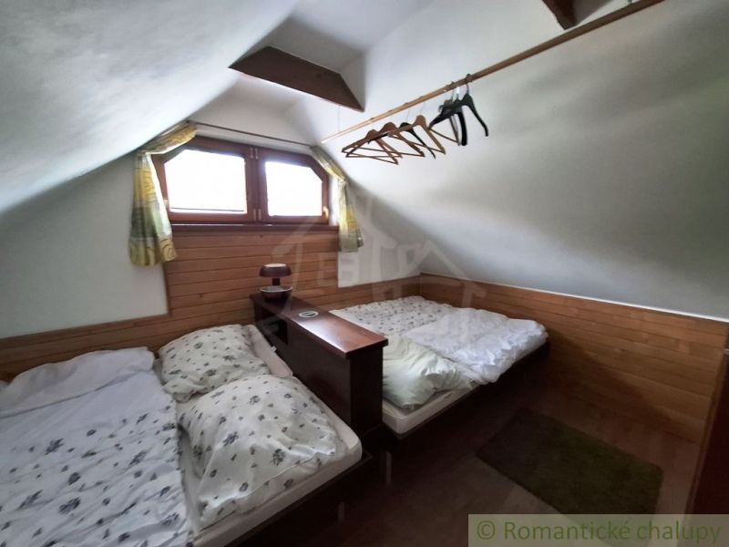 Attic room with two beds and a wooden decor floor in commercial premises.