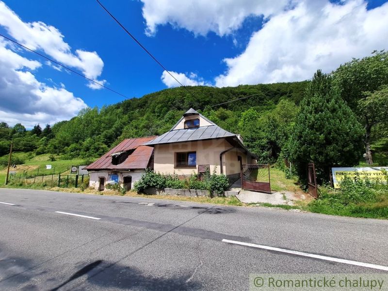 Commercial premises in Mýto pod Ďumbierom by the road, surrounded by greenery and trees.