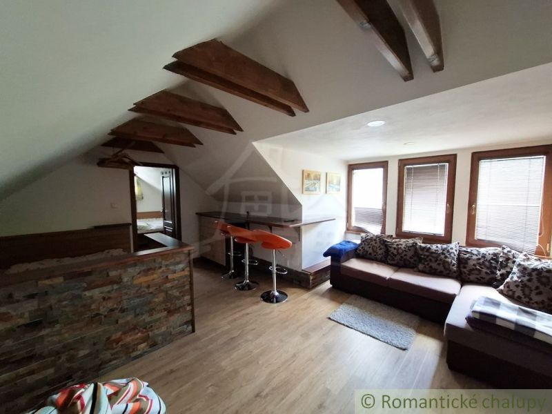 Attic commercial space with wood-patterned flooring and comfortable seating.