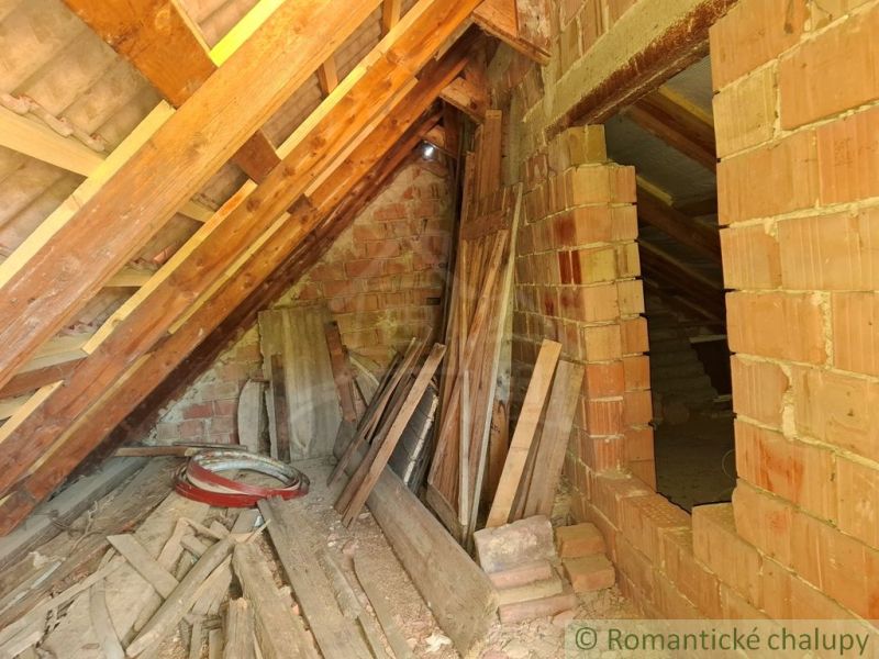 Attic with building materials in a cottage, bricks and wooden beams in Gbelce.