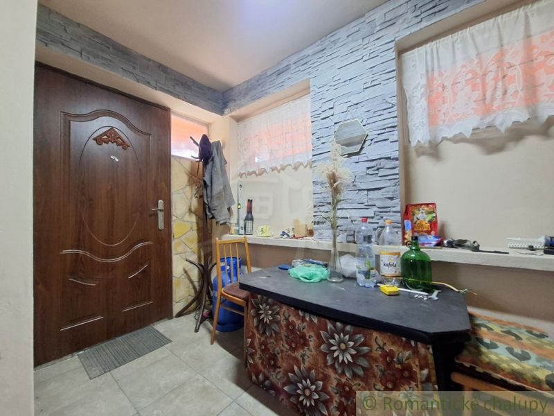Interior of a cabin with stone cladding and wooden doors.