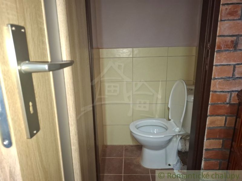 A bathroom with tiles and a brick wall in the interior of a cottage.
