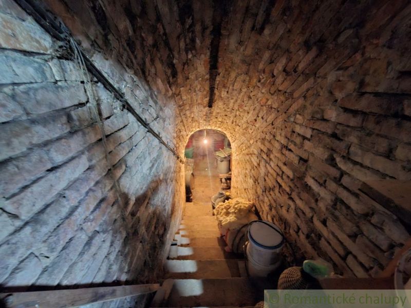 Stone vaulted basement in the cottage with stored items.