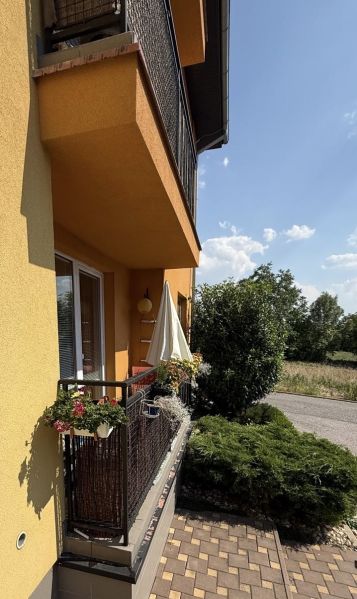 The balcony of a 3-room apartment in Veľký Lapáš with a railing full of flowers.