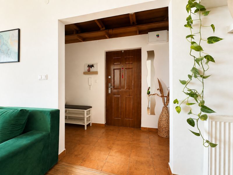 The entrance hall in a 3-room apartment with a green sofa and decorations.