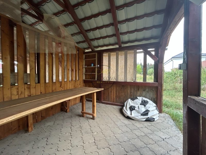A wooden shelter in Telince and a 2-room apartment with a stone floor in the background.