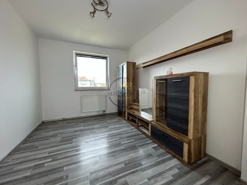 Living room in a 2-room apartment with a wooden decor floor and furniture.