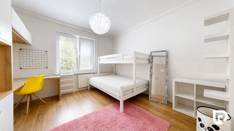 Children's room in a 3-room apartment with a bunk bed, yellow chair, shelves, and a wooden decor floor.