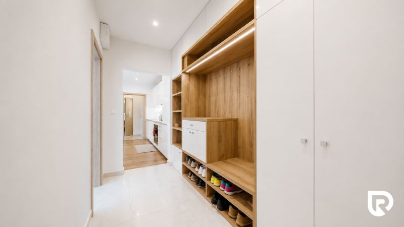 A hallway with a shoe cabinet and a wardrobe in a 3-room apartment, wood decor and white elements.