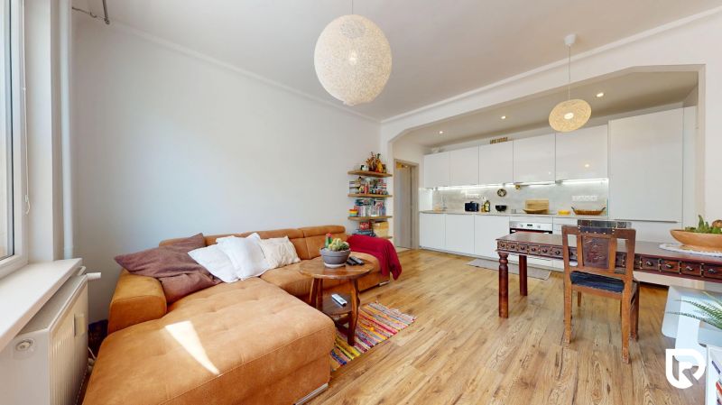 Living room with kitchen in a three-room apartment with a wooden decor floor.