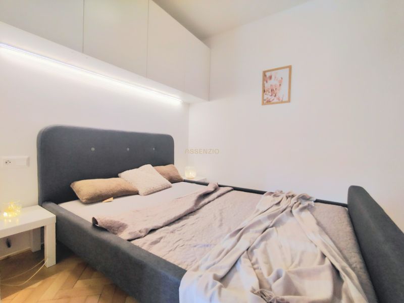 A bedroom with a comfortable bed, a white wardrobe, and decoration in a two-room apartment.