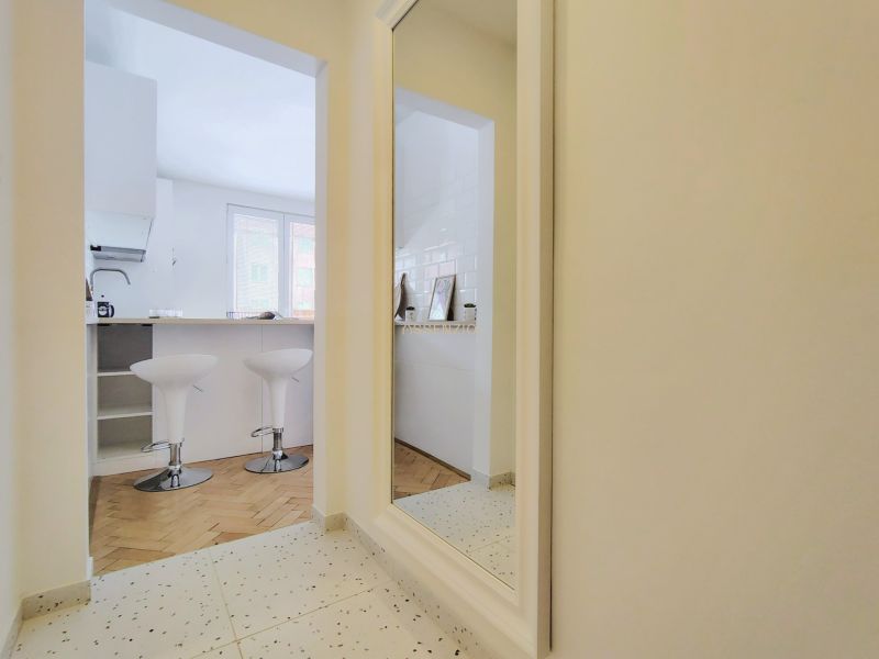 Bar stools in the kitchen at the counter, 2-room apartment, floor with wooden decor.