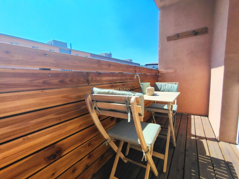 A balcony with wooden decor and garden furniture in a 2-room apartment.