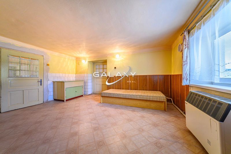 A room in a family house with one bed, a cabinet, and laminate flooring.