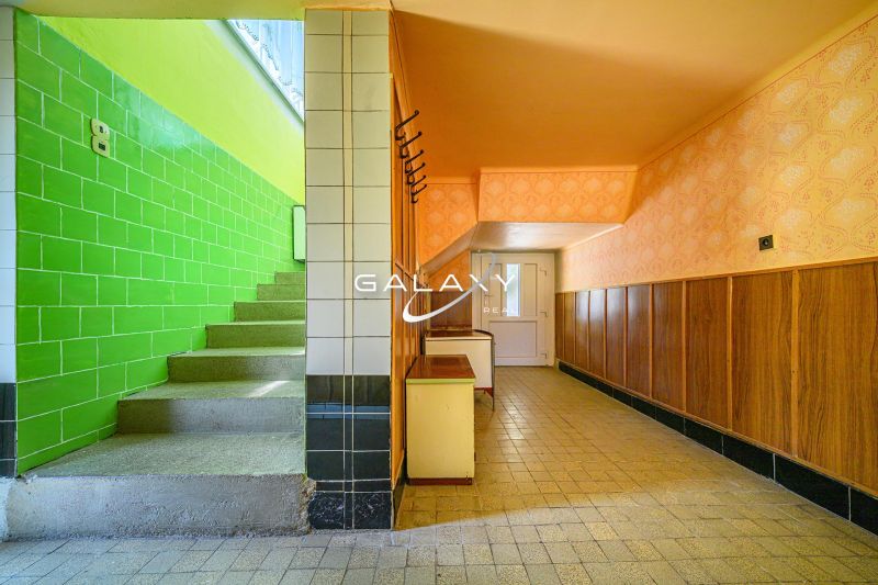Interior of a family house with tiles, painted walls, and wooden paneling.