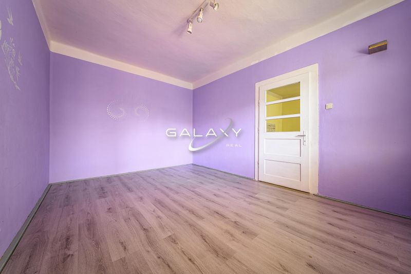 Purple room with a light wooden-patterned floor in a family house.