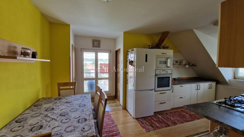 A kitchen in a 2-room apartment with a wooden decor and a yellow wall.