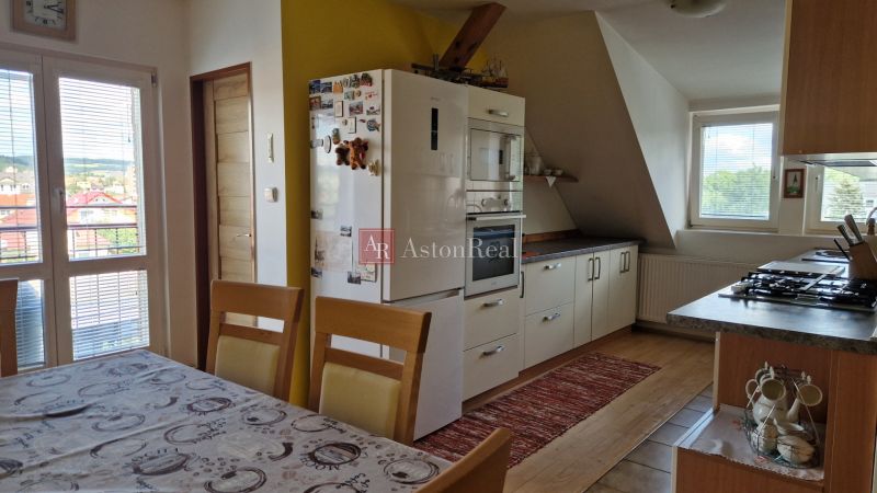 A kitchen in a 2-room apartment with a wooden decor floor and a dining table.