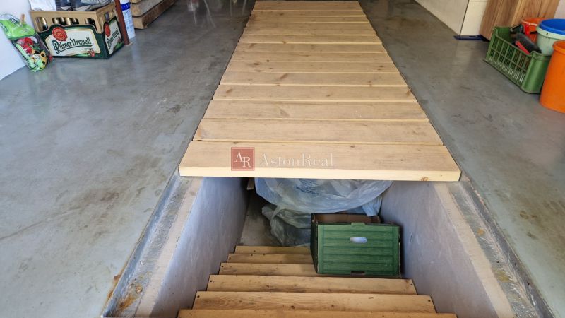 A cellar with a wooden hatch and details on stored items.