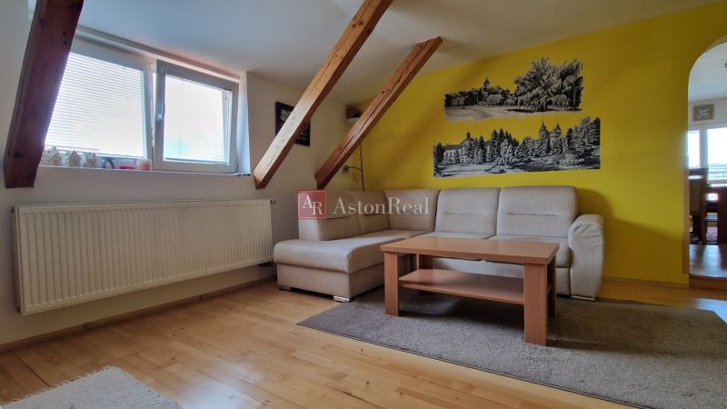 Living room with a sofa, table, and wooden decor flooring in a 2-room apartment.