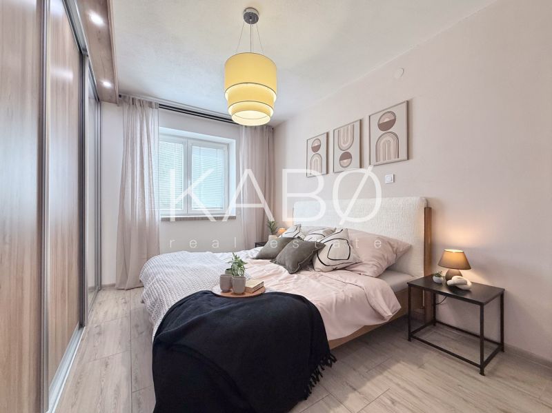 Bedroom in a 2-room apartment with a wooden decor floor and wall decoration.