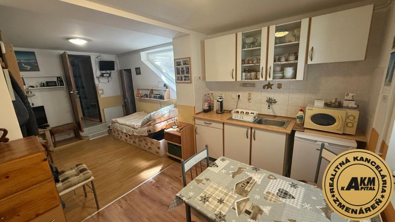 Kitchen corner with cabinets, table, and sofa, wooden decor flooring in a family house.
