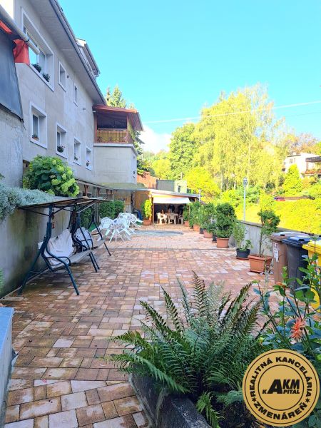 A family house in Zvolen with a paved courtyard and a garden seating area.