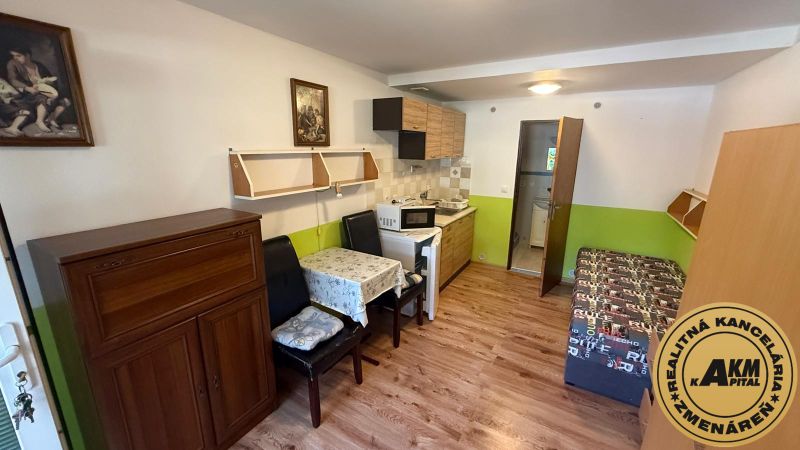 Interior with a kitchenette, table, and wooden decor flooring in a family house.
