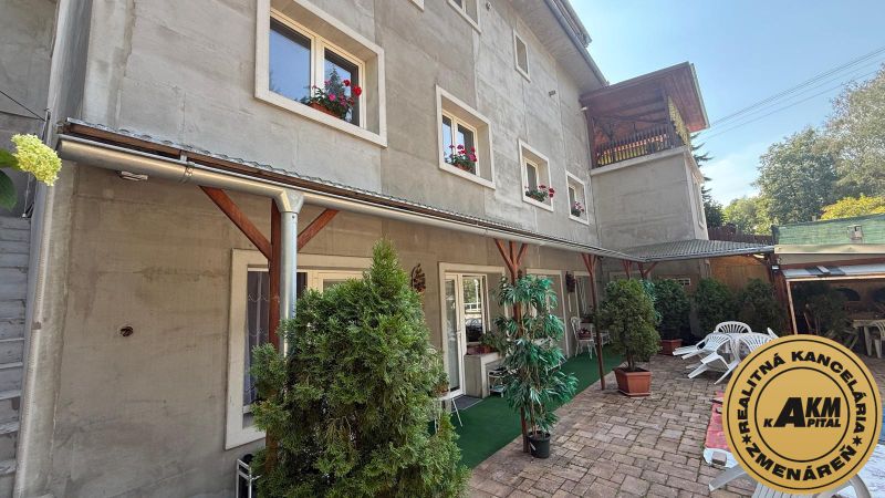 A family house in Zvolen with green plants on the terrace and windows with flowers.