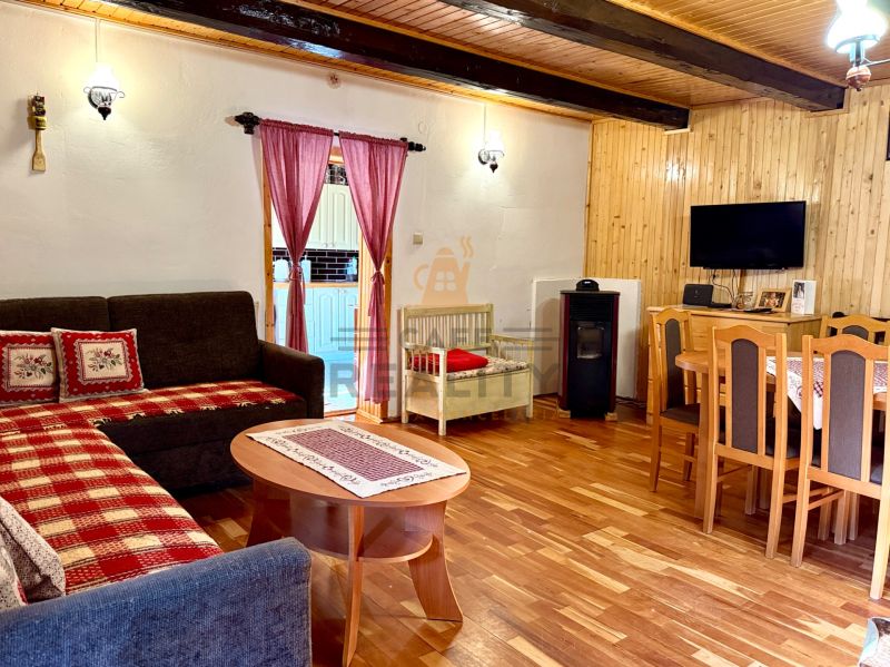 Living room with a fireplace, television, and wood-patterned flooring in a family house.