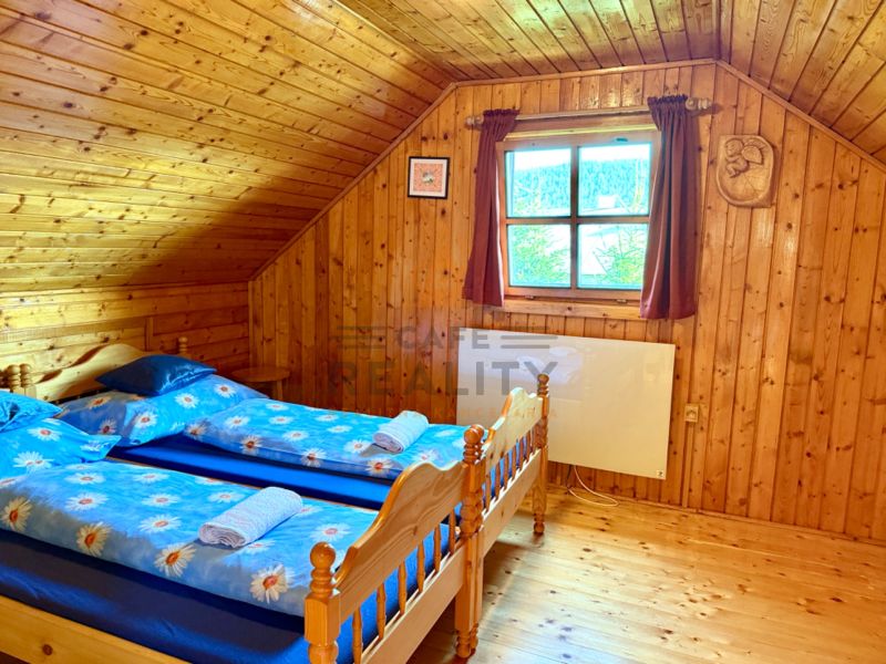 Wooden interior with wood-patterned flooring and two beds in a family house.