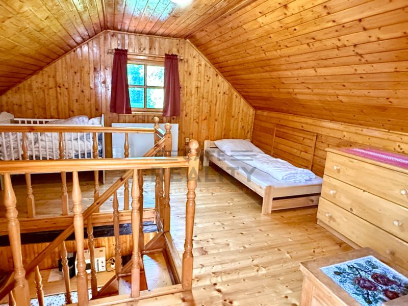 The attic of a family house with wooden paneling and a floor with a wood decor.