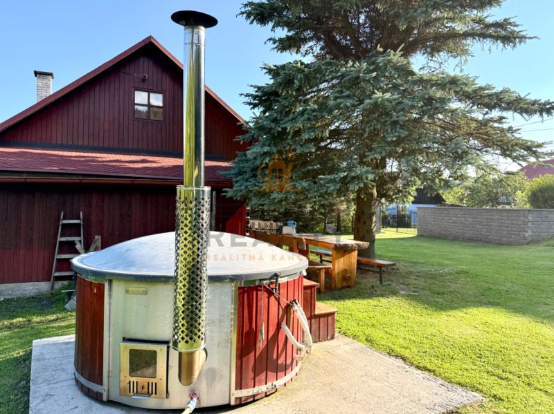 A family house on Jána Švermu Street in Šumiac with a hot tub and a wooden table in the garden.