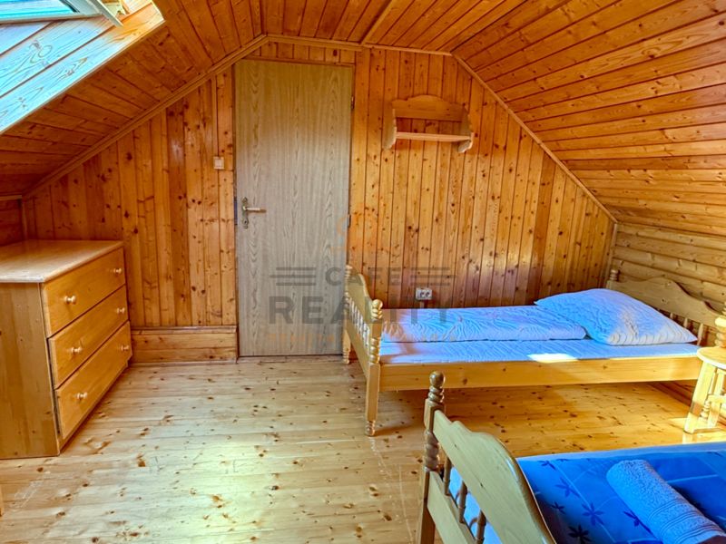 An attic room in a family house with wooden decor and simple furnishings.