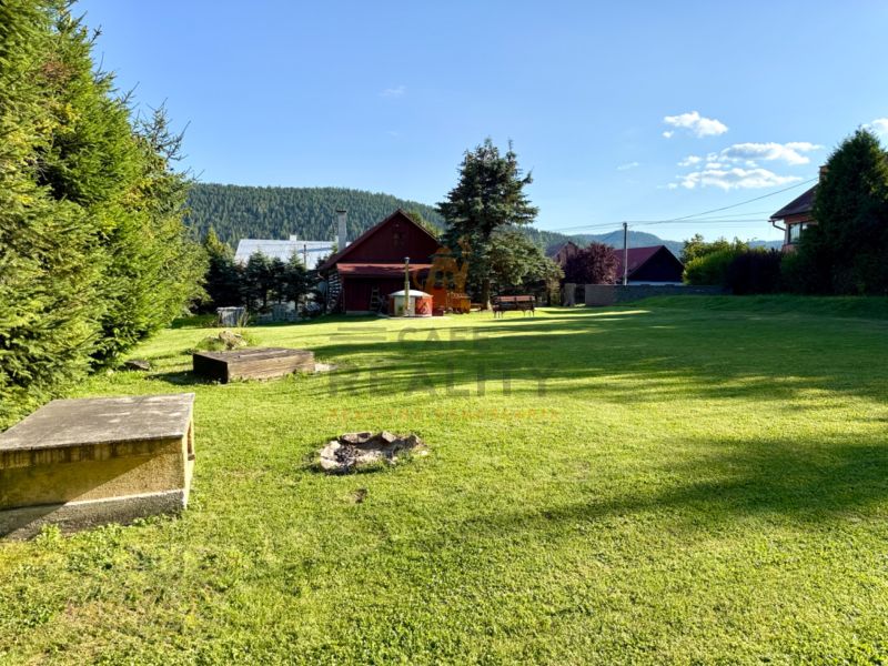 The garden at the family house on Jána Švermu Street in Šumiac with a lawn and a fireplace.