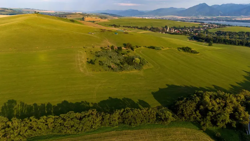 Extensive green fields and hills in Liptovský Trnovec, offering a view of peculiar properties.