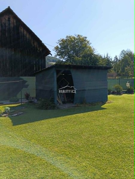 A garden with a wooden cottage and grassy area in Ovčiarsko, suitable for residential land.