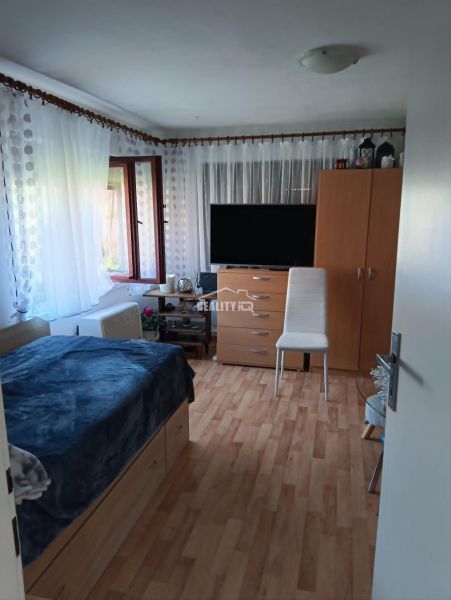 Room with a television, bed, and floor with wood decor, Properties - living.