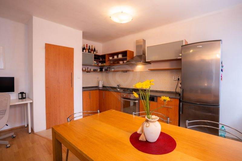 A kitchen in a 4-room apartment with a wooden decor and a yellow floral accessory.