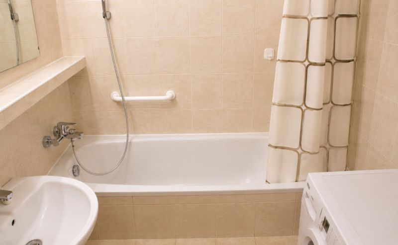 A bathroom in a 2-room apartment with a bathtub, shower, and washing machine.